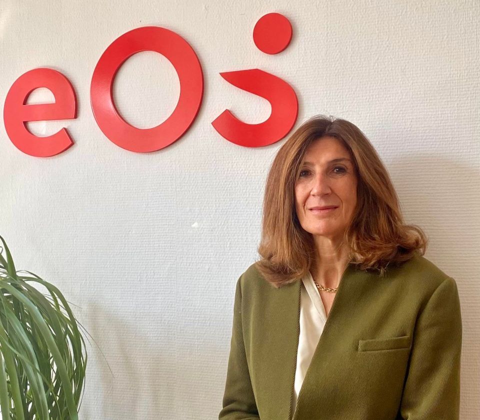 Nathalie Lameyre sitting in front of a white wall with an EOS logo 
