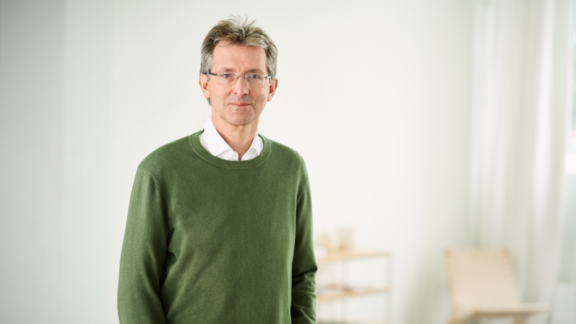 Justus Hecking-Veltman, CFO, dans une pièce lumineuse, vêtu d’un pull vert foncé et d’une chemise blanche.