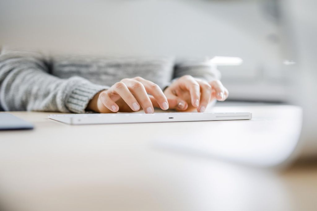 Jeune femme écrivant sur l'ordinateur