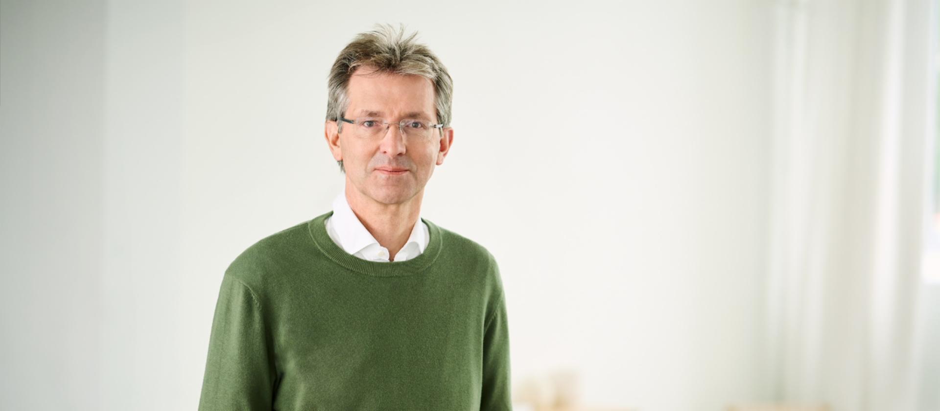 Justus Hecking-Veltman, CFO, dans une pièce lumineuse, vêtu d’un pull vert foncé et d’une chemise blanche.